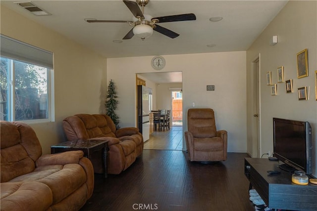 living room with ceiling fan, dark wood-type flooring, and a wealth of natural light