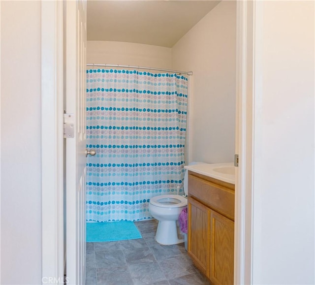 bathroom with toilet, vanity, and walk in shower