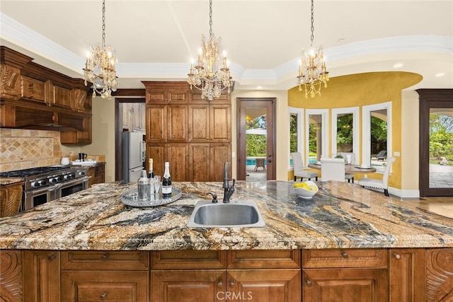 kitchen featuring pendant lighting, white refrigerator, sink, high end stainless steel range oven, and tasteful backsplash