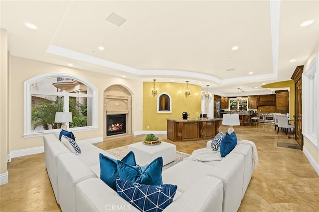 living room featuring a raised ceiling and an inviting chandelier