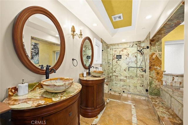 bathroom featuring vanity, a shower with shower door, and a tray ceiling