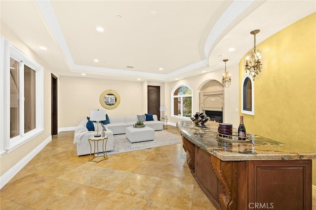 living room with a tray ceiling and an inviting chandelier