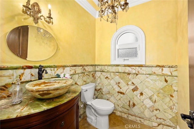 bathroom featuring toilet, vanity, an inviting chandelier, and ornamental molding