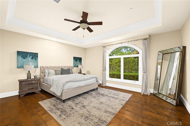 bedroom featuring dark hardwood / wood-style floors, ceiling fan, and a raised ceiling