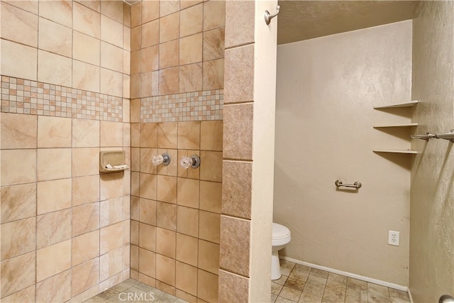 bathroom with tile patterned flooring, a tile shower, and toilet