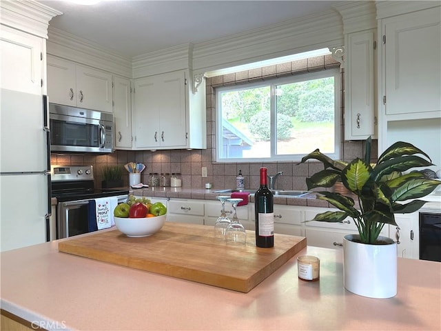 kitchen with tasteful backsplash, white cabinetry, and appliances with stainless steel finishes