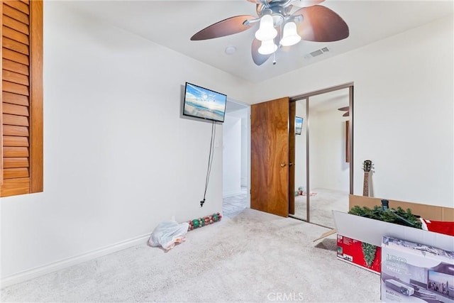 bedroom featuring ceiling fan, a closet, and light carpet