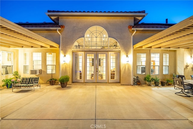 exterior entry at twilight with french doors and a patio area