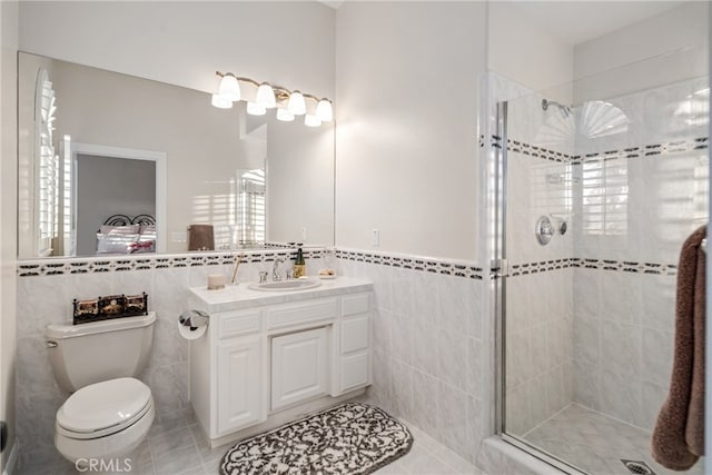 bathroom featuring tile flooring, tile walls, and toilet