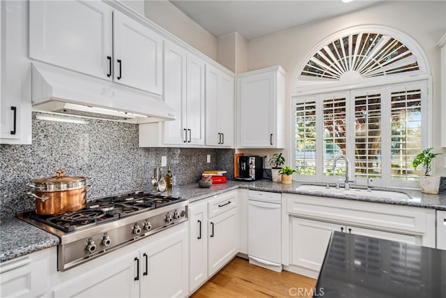 kitchen featuring light stone countertops, stainless steel gas stovetop, light hardwood / wood-style floors, white cabinets, and sink