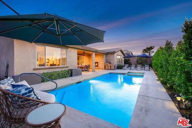 pool at dusk with a patio