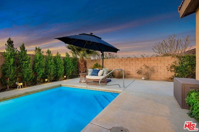 pool at dusk with a patio