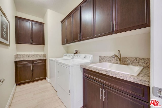 laundry room featuring sink, cabinets, hookup for a washing machine, and washing machine and clothes dryer