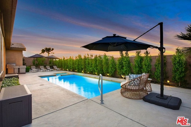 pool at dusk with a patio