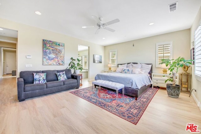 bedroom featuring multiple windows, ceiling fan, and light wood-type flooring