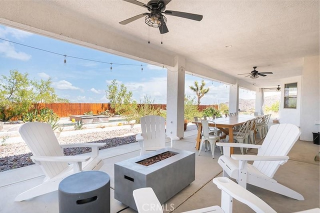 view of patio with ceiling fan and an outdoor fire pit