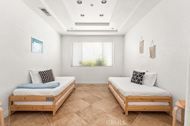 sitting room featuring tile patterned floors and a tray ceiling