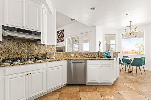 kitchen featuring white cabinetry, stainless steel appliances, dark stone countertops, sink, and backsplash