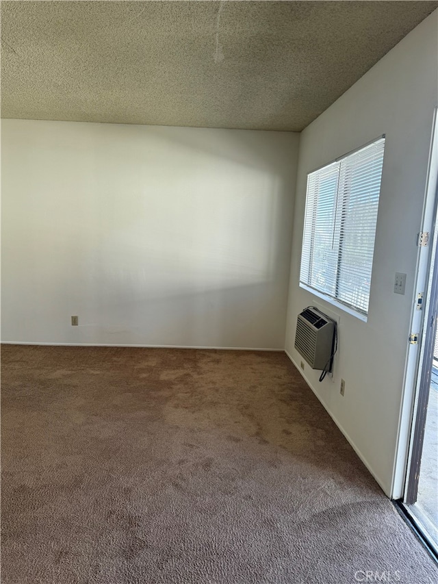 carpeted spare room featuring a textured ceiling and a wall unit AC