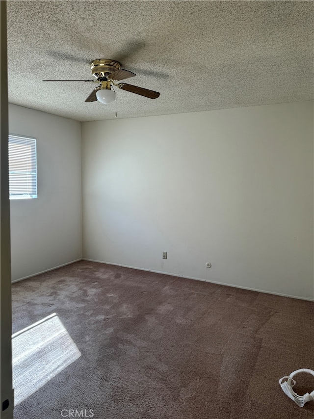 carpeted spare room with ceiling fan and a textured ceiling