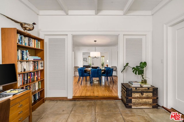 interior space featuring a notable chandelier, beamed ceiling, and light tile floors