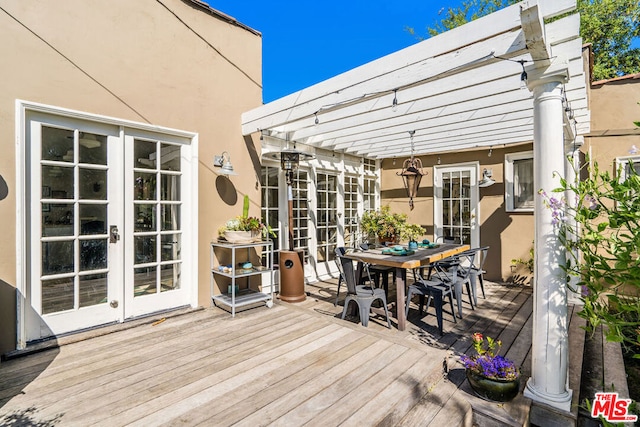 wooden deck with french doors and a pergola