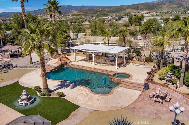 view of pool with a mountain view, an in ground hot tub, and a patio