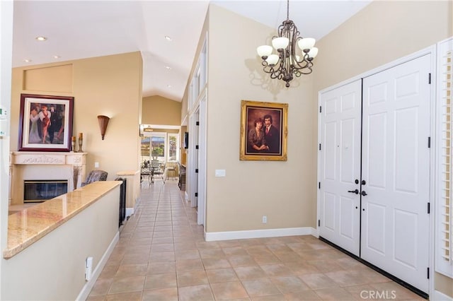 tiled entrance foyer with high vaulted ceiling and a notable chandelier