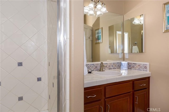 bathroom featuring decorative backsplash, vanity, a chandelier, and walk in shower