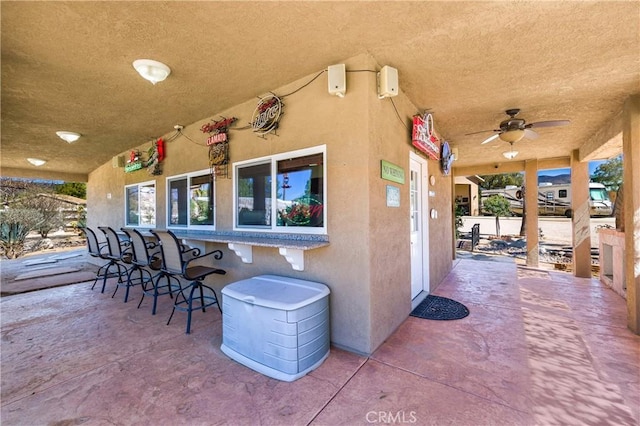 view of patio with ceiling fan and exterior bar