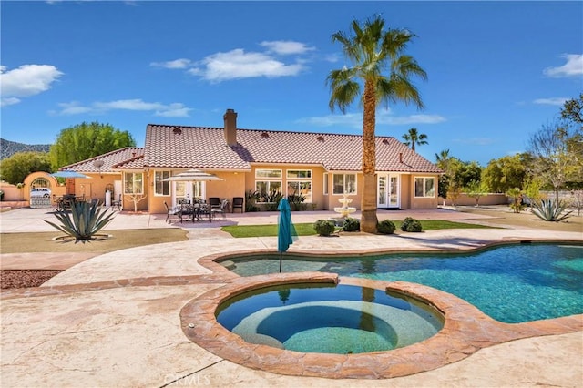 view of swimming pool featuring an in ground hot tub, french doors, and a patio