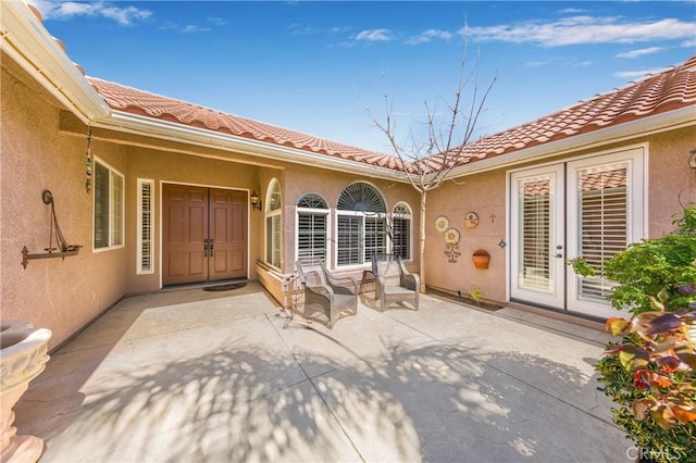 entrance to property featuring a patio area and french doors