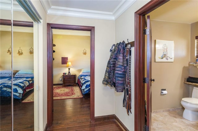 corridor with hardwood / wood-style flooring and ornamental molding