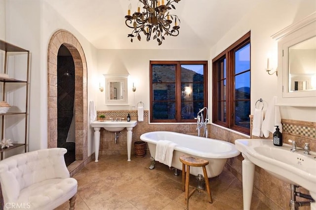 2835 Hermitage Rd, Ojai, CA 93023 - bathroom featuring a freestanding tub, a wainscoted wall, a sink, a chandelier, and tile walls