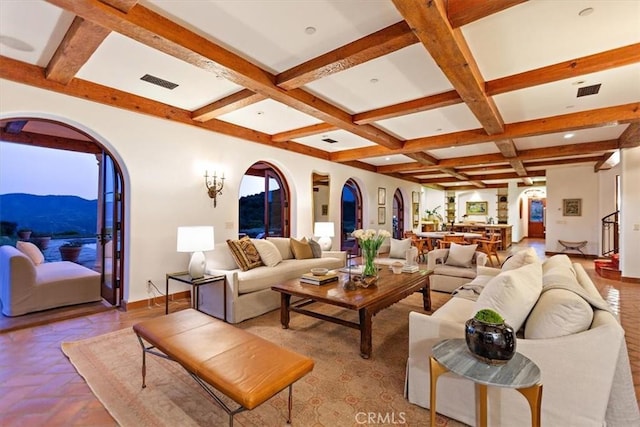 living room featuring beam ceiling, a mountain view, and coffered ceiling