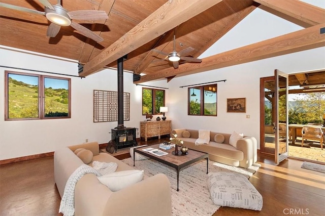 living room featuring beamed ceiling, a wood stove, a wealth of natural light, and wood ceiling