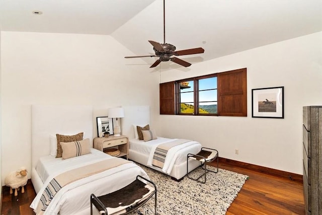 bedroom featuring ceiling fan, dark hardwood / wood-style flooring, and lofted ceiling