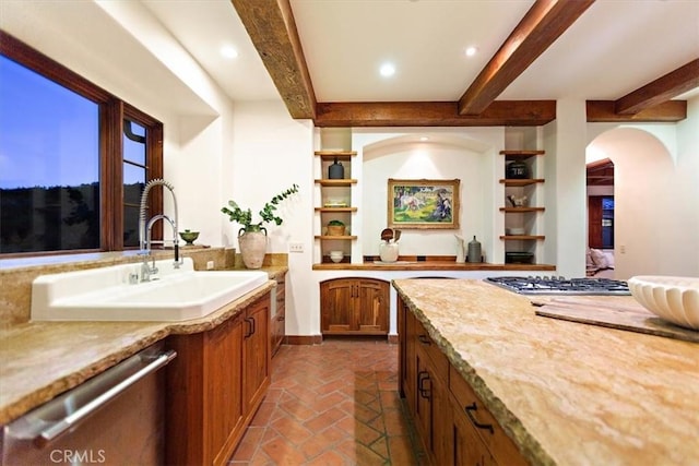 kitchen featuring appliances with stainless steel finishes, beam ceiling, and sink