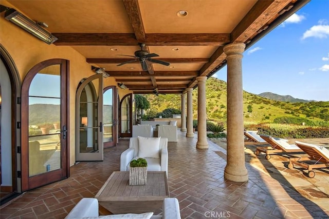 view of patio with a mountain view, french doors, and ceiling fan