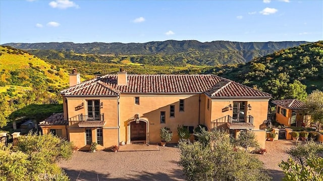 view of front of home with a mountain view and a balcony