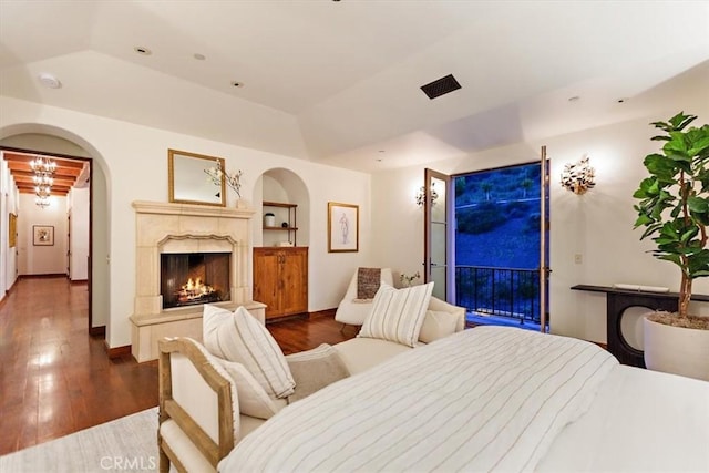 2835 Hermitage Rd, Ojai, CA 93023 - bedroom featuring baseboards, a fireplace, wood finished floors, arched walkways, and a tray ceiling