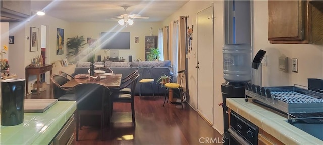 dining area with dark wood-type flooring and ceiling fan