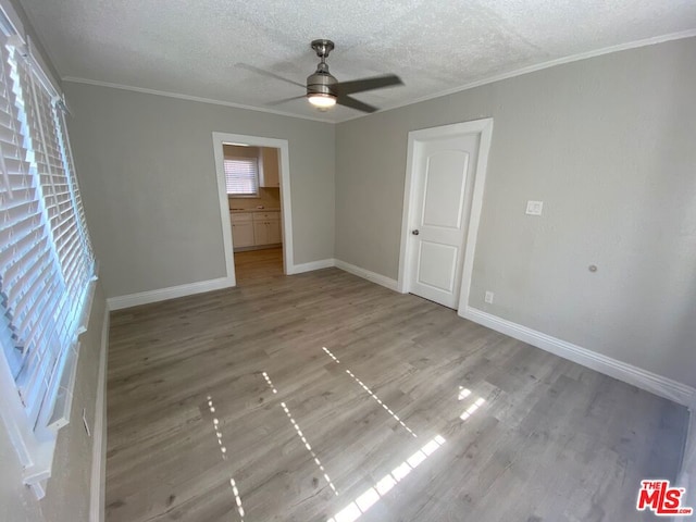 unfurnished room with ceiling fan, hardwood / wood-style flooring, crown molding, and a textured ceiling