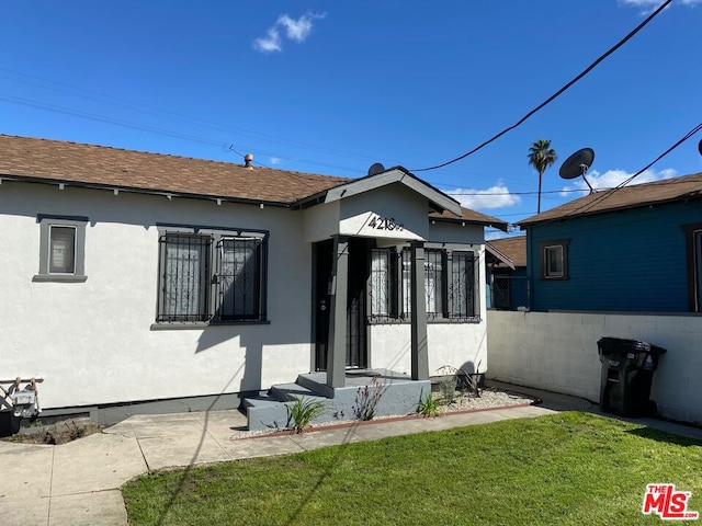 rear view of house featuring a lawn