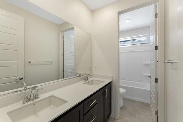 bathroom with toilet, vanity, and tile patterned floors