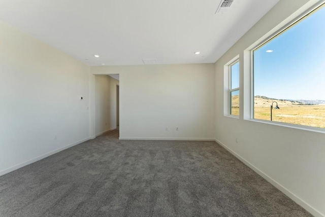 unfurnished room featuring dark carpet