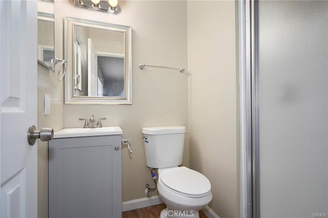 bathroom with wood-type flooring, vanity, and toilet