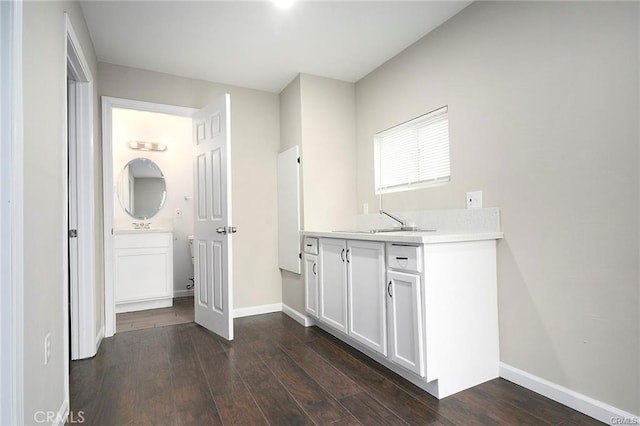 interior space with white cabinets, dark wood-type flooring, and sink