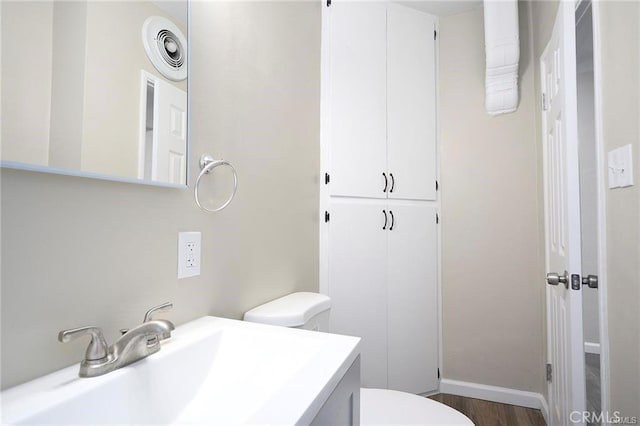6454 Goleta Ave, Yucca Valley, CA 92284 - bathroom featuring toilet, wood finished floors, vanity, and baseboards
