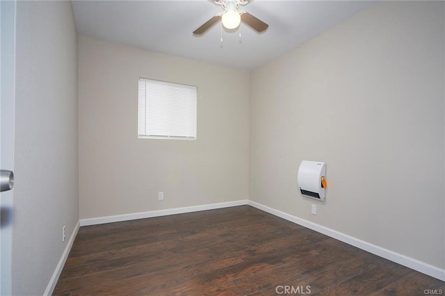 spare room featuring ceiling fan, dark hardwood / wood-style flooring, and heating unit